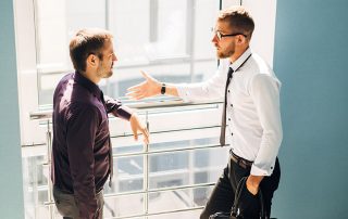 two men talking in the lobby of the office